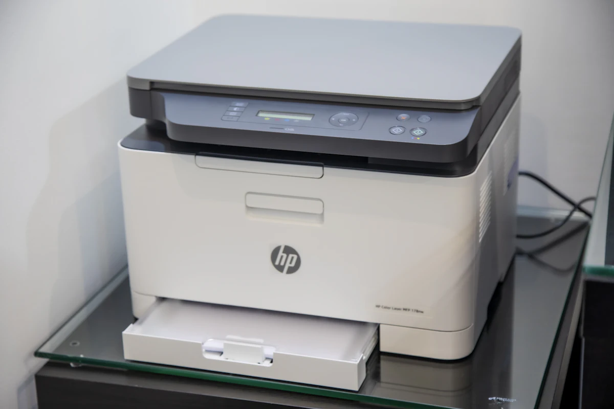 Printer putih di atas meja kerja