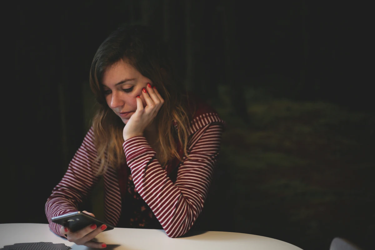 Perempuan menatap layar ponsel dalam waktu lama sebelum memutuskan membalas pesan