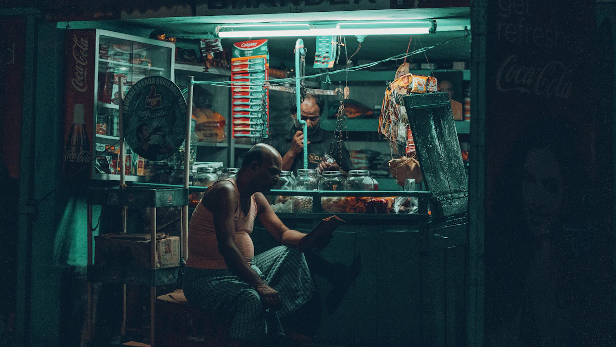 Seorang laki-laki duduk di depan tokonya yang penuh barang dagangan