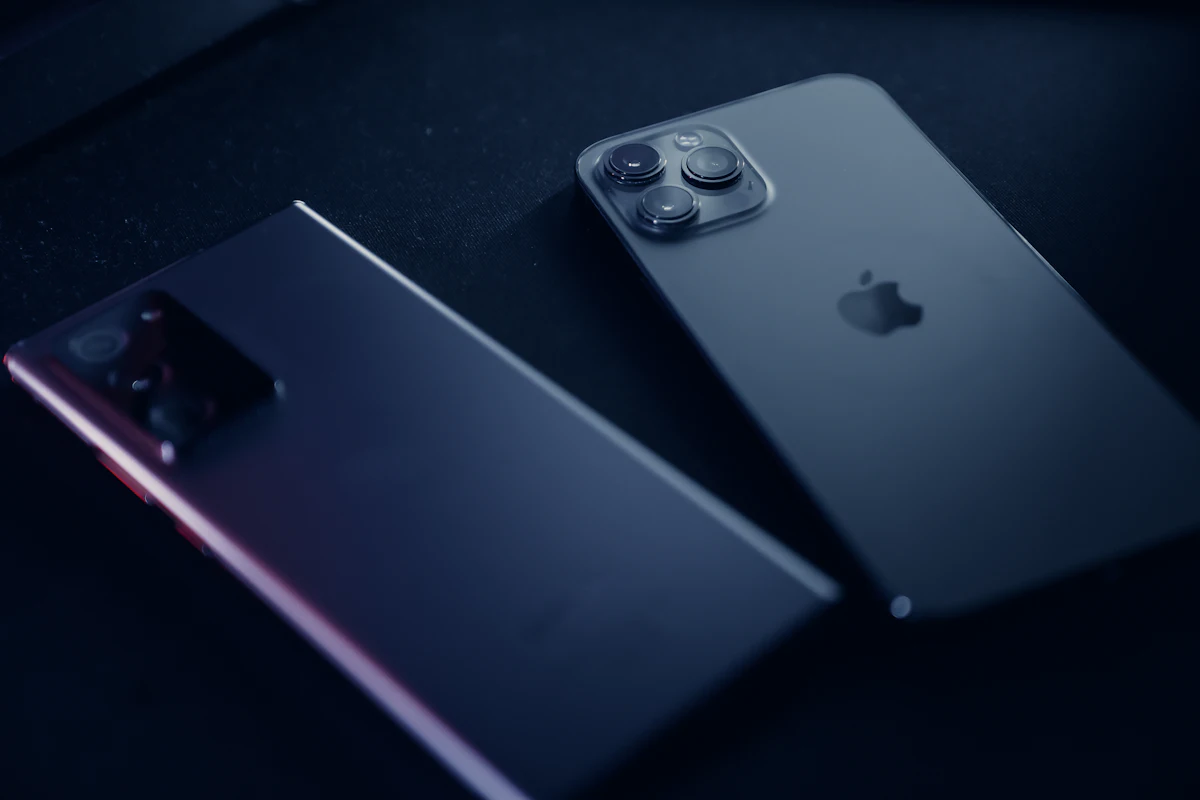 Ponsel iPhone dan ponsel Android tergeletak berdampingan di atas meja