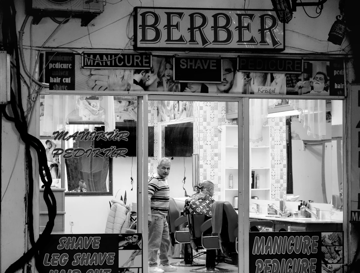 Bagian dalam sebuah barbershop kecil dengan pelanggan yang sedang dilayani