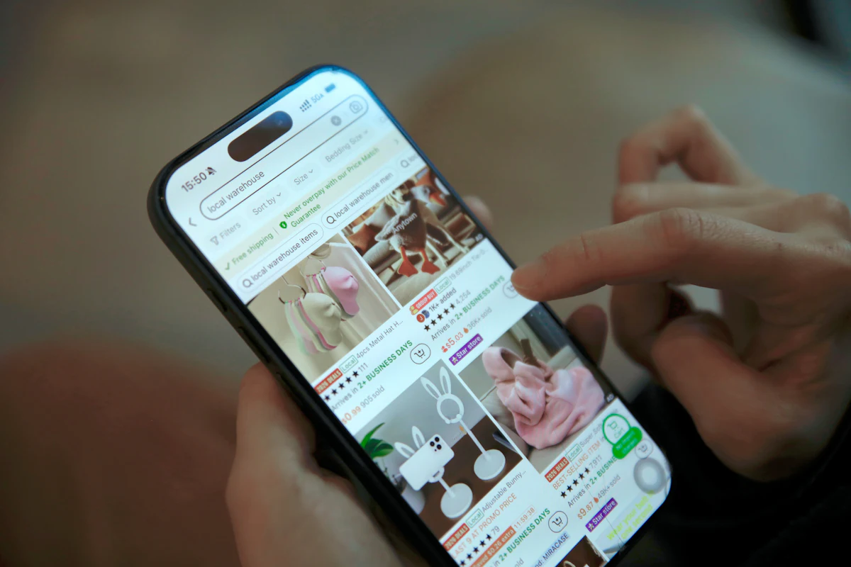 Tangan menggulir aplikasi belanja online dengan halaman produk berbintang dan jumlah terjual