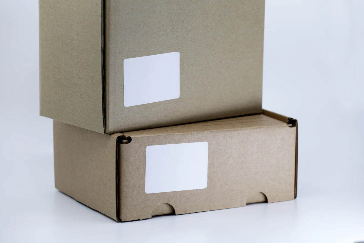 Kardus paket cokelat dengan label pengiriman di atas meja