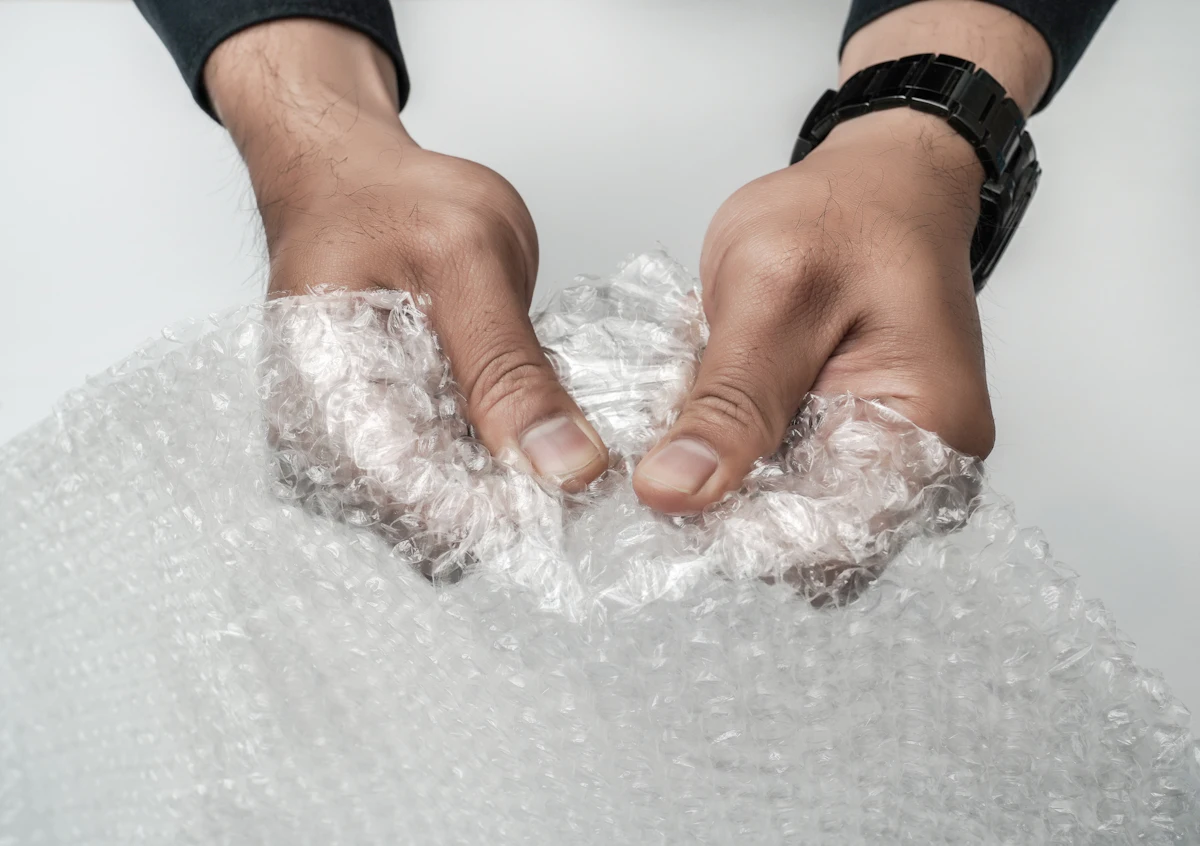 Tangan pekerja menyiapkan produk untuk dikemas dan dikirim